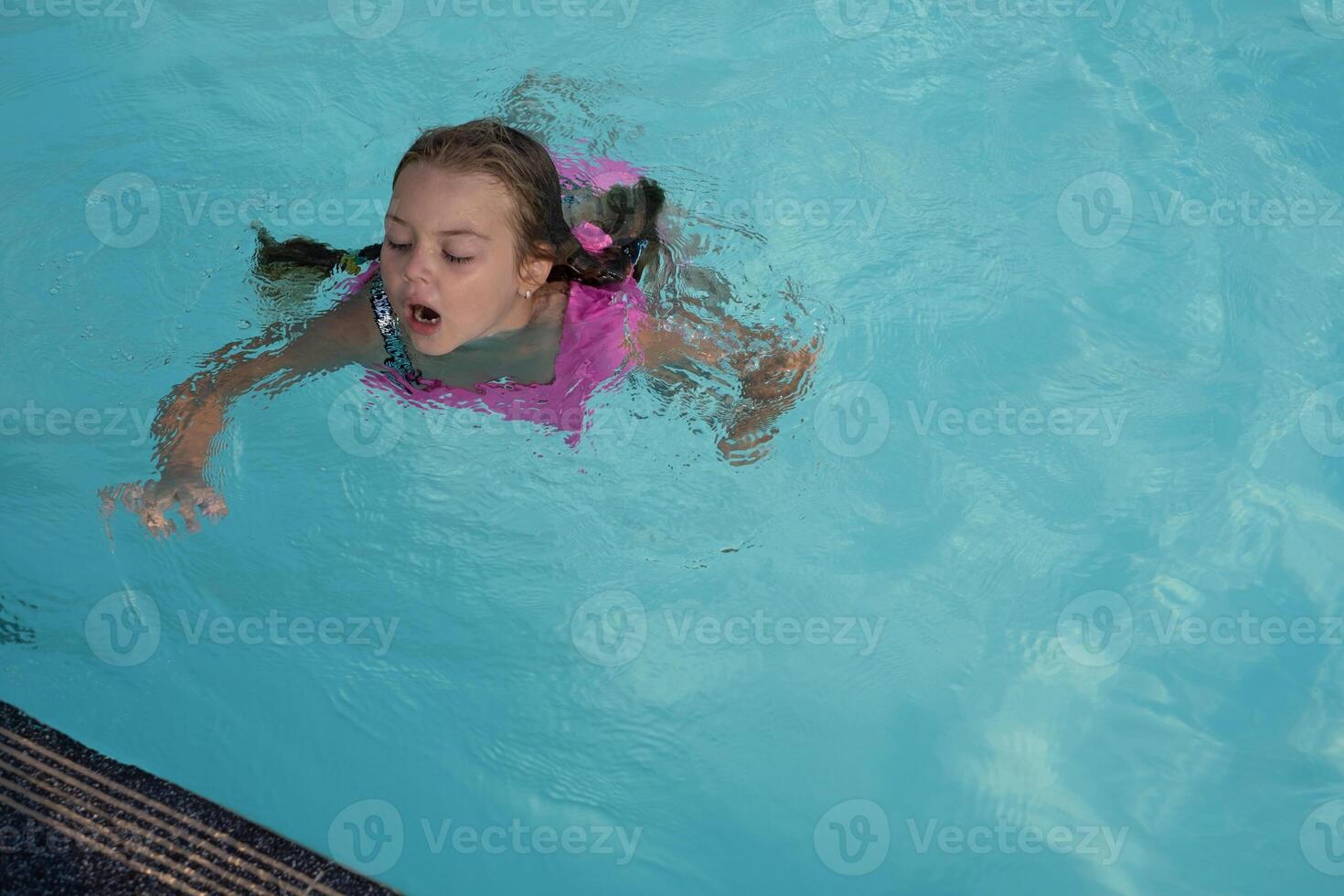 Girl is swimming in the pool photo