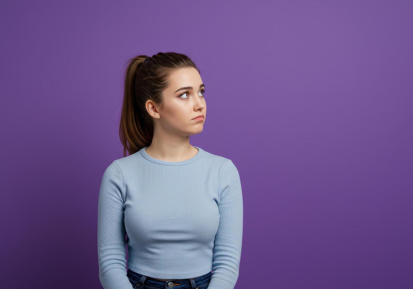 A young woman is looking up at something on a purple background photo
