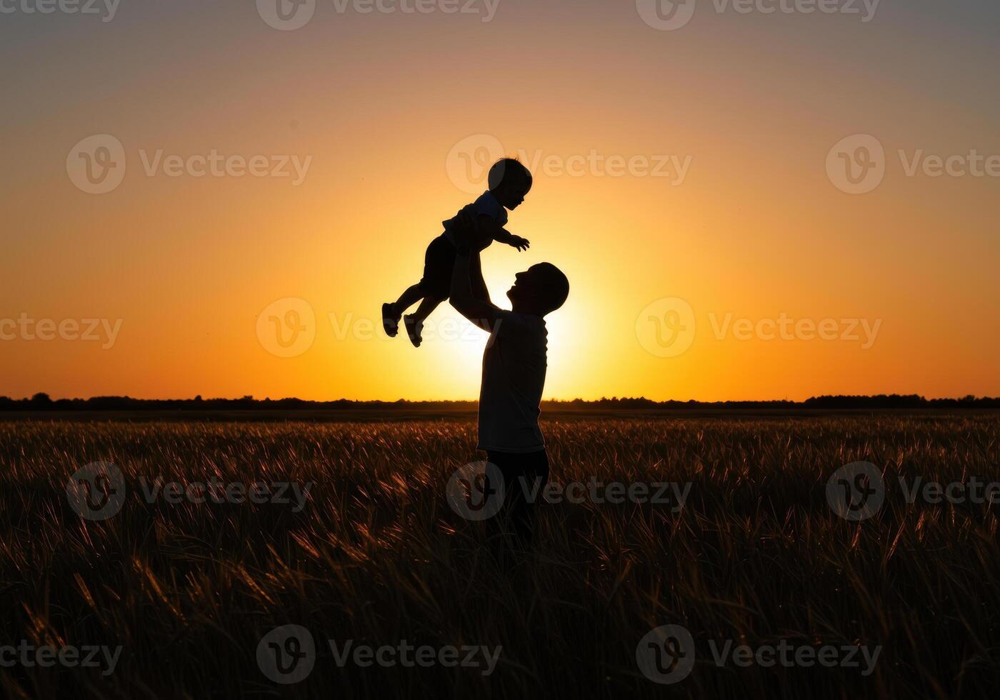 A man holding a child in the air at sunset photo