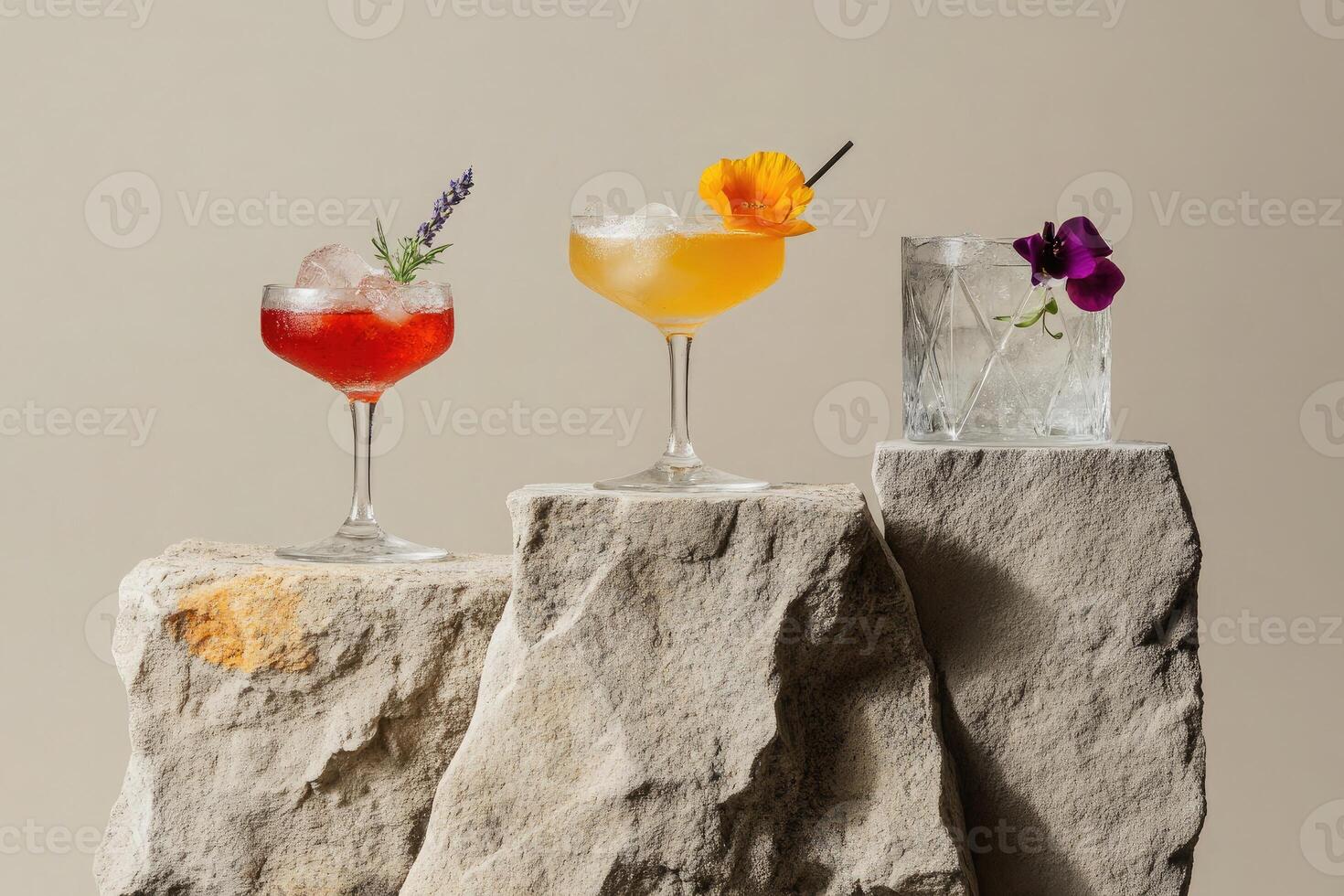 Elegant tea cocktails in uniquely shaped glasses on stone slabs with soft beige and gray backdrop photo