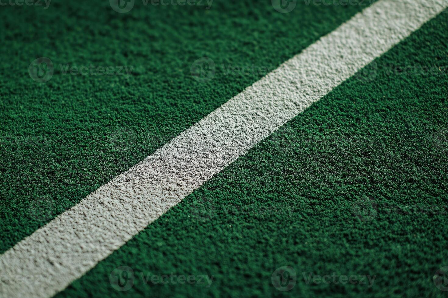 White boundary line on green artificial football pitch, with clear texture details and rich natural lighting photo