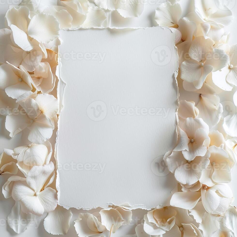Top view composition of white blank card framed by soft white rose flower petals, perfect for romantic messages, event invitations and branding designs photo