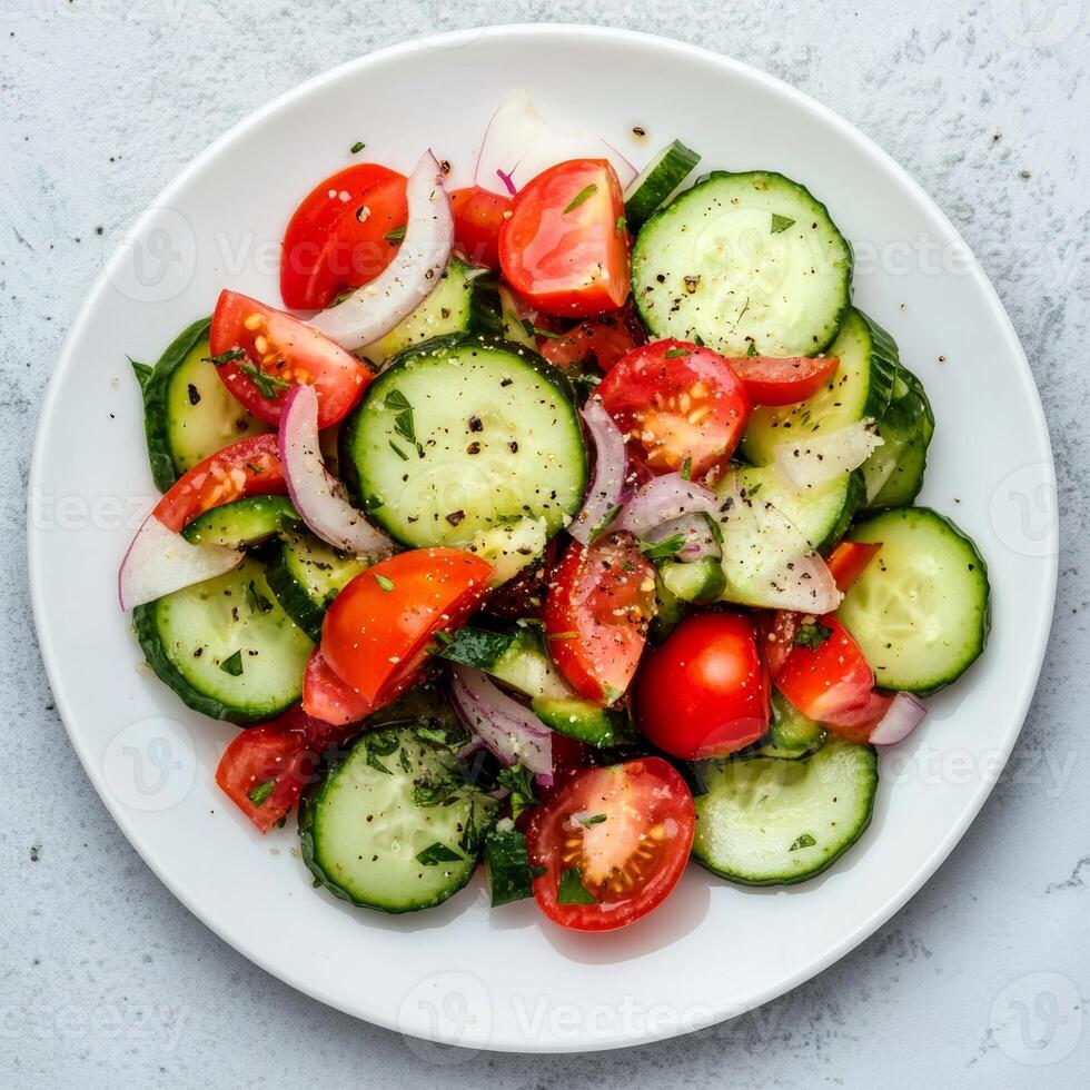 Fresh cucumber slices, cherry tomatoes, and thin red onion rings tossed with aromatic herbs, seasoned with cracked black pepper for a crisp, zesty salad photo