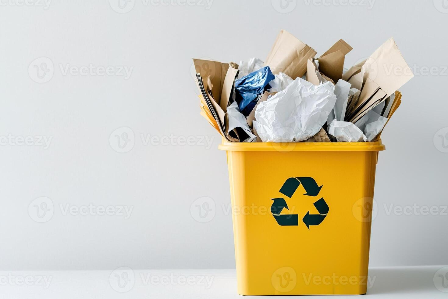 recyclable waste inside open yellow container with recycling sign on white background with copy space. Great for topics about environmental responsibility and waste sorting photo