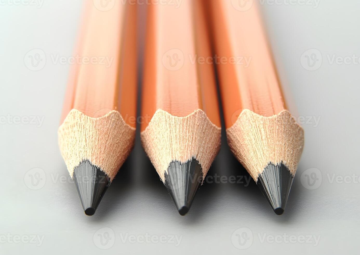 three pencils lined up perfectly parallel on clean desk surface photo