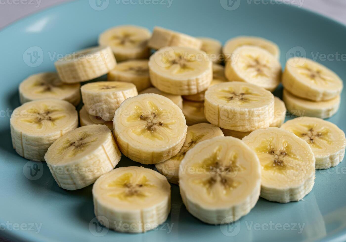 Close up shot of fresh banana slices on a vibrant blue plate, perfect for healthy eating. photo