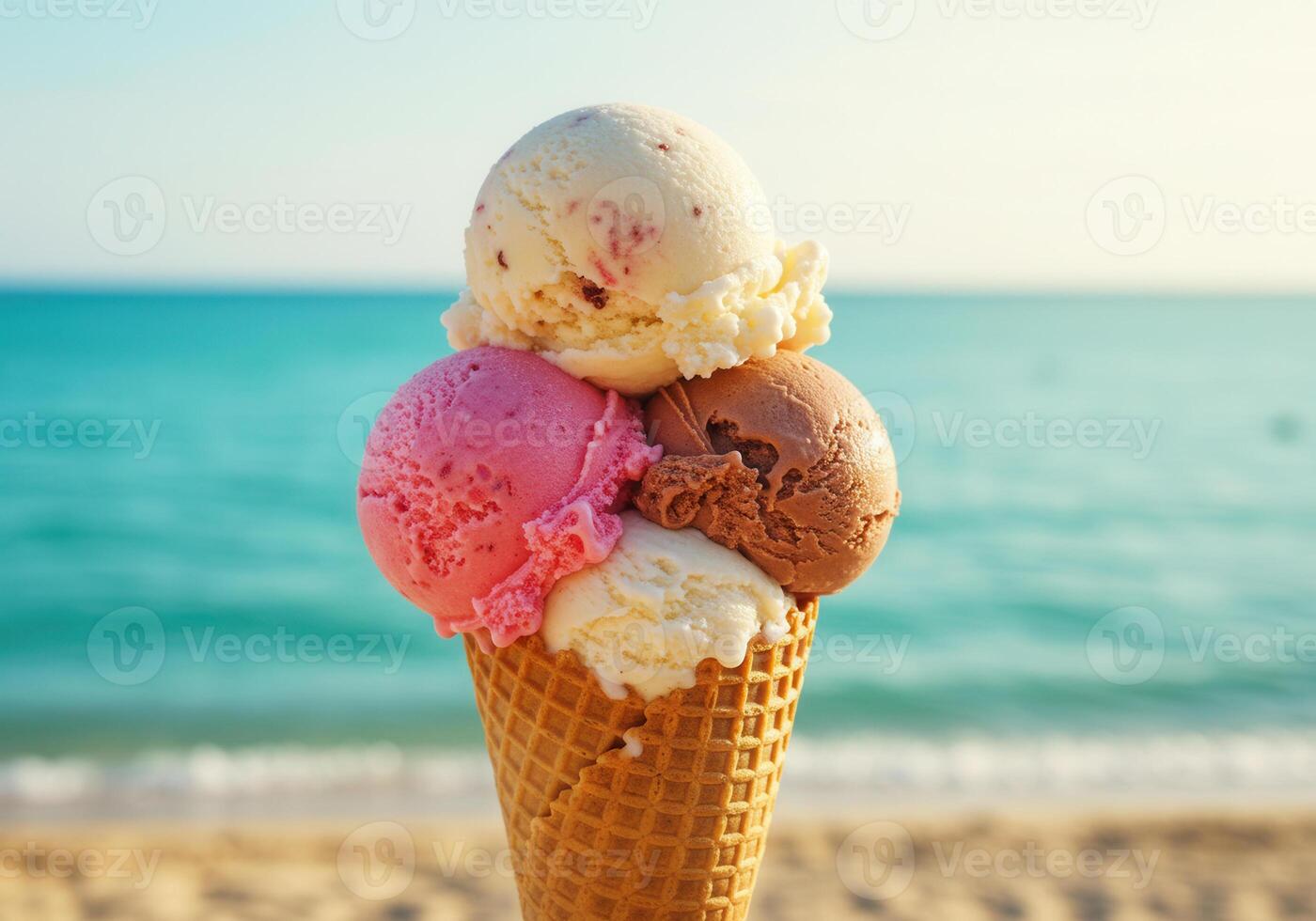 A multi flavored ice cream cone is enjoyed at the beach on a beautiful sunny day. photo