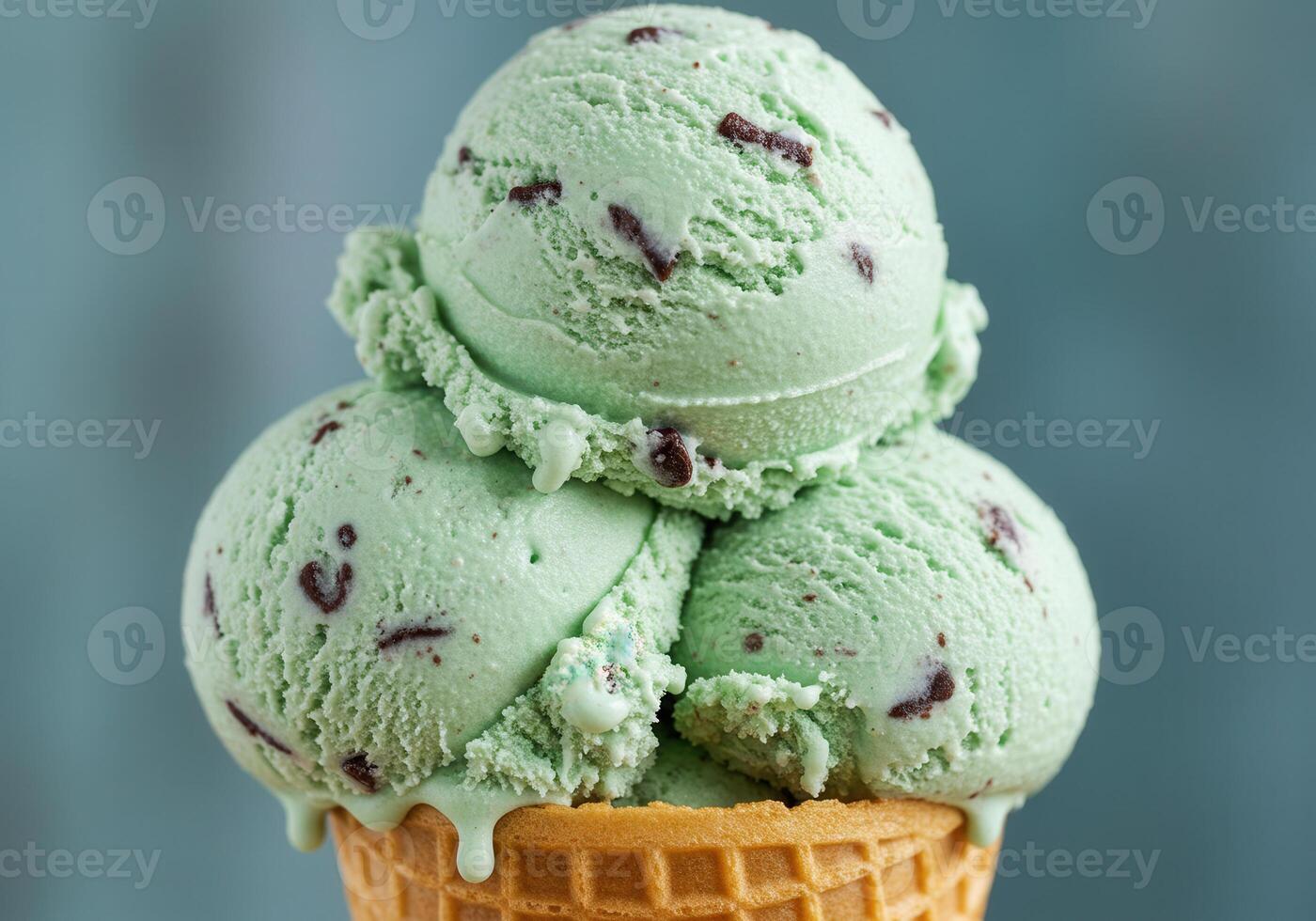 Three refreshing scoops of mint chocolate chip ice cream in a crispy waffle cone. photo