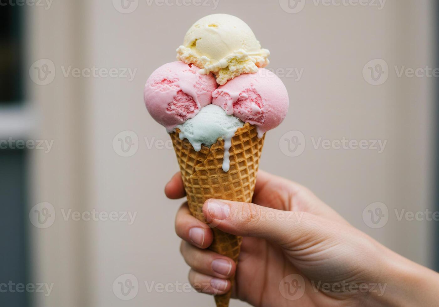 A close up of a hand holding a delicious ice cream cone with colorful scoops. photo