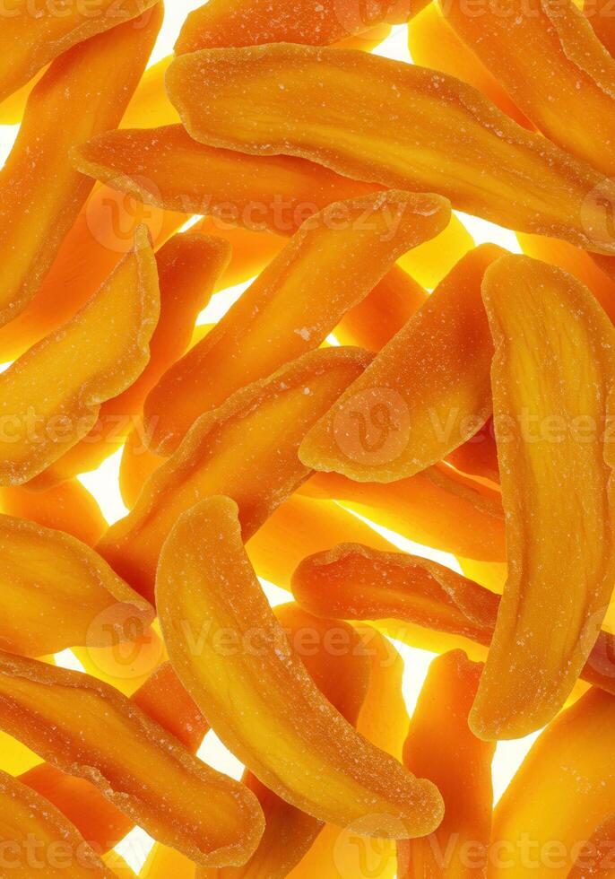 A bright, close up view of several overlapping dried mango slices, ready to eat. photo