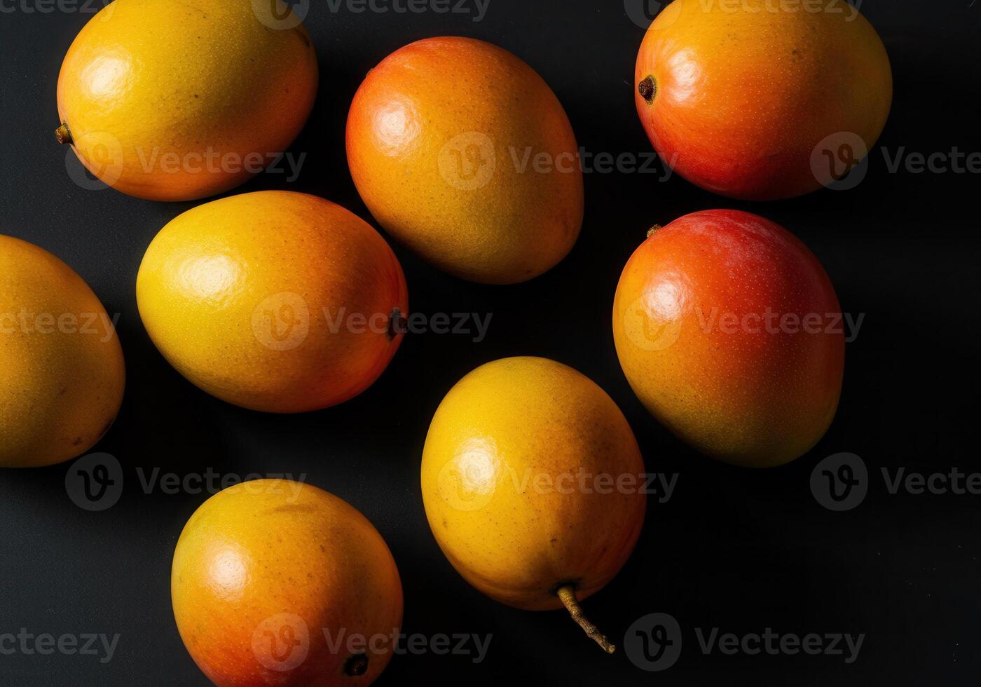 A collection of vibrant, ripe mangoes, arranged on a contrasting dark background. photo