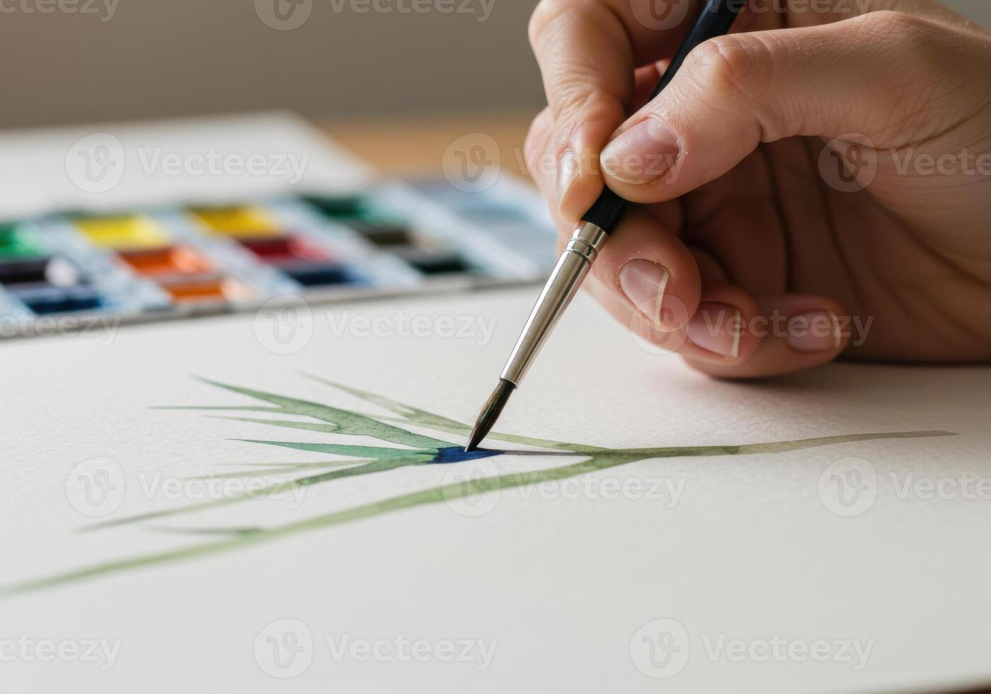 An artist's hand delicately paints a watercolor botanical illustration on white paper. photo
