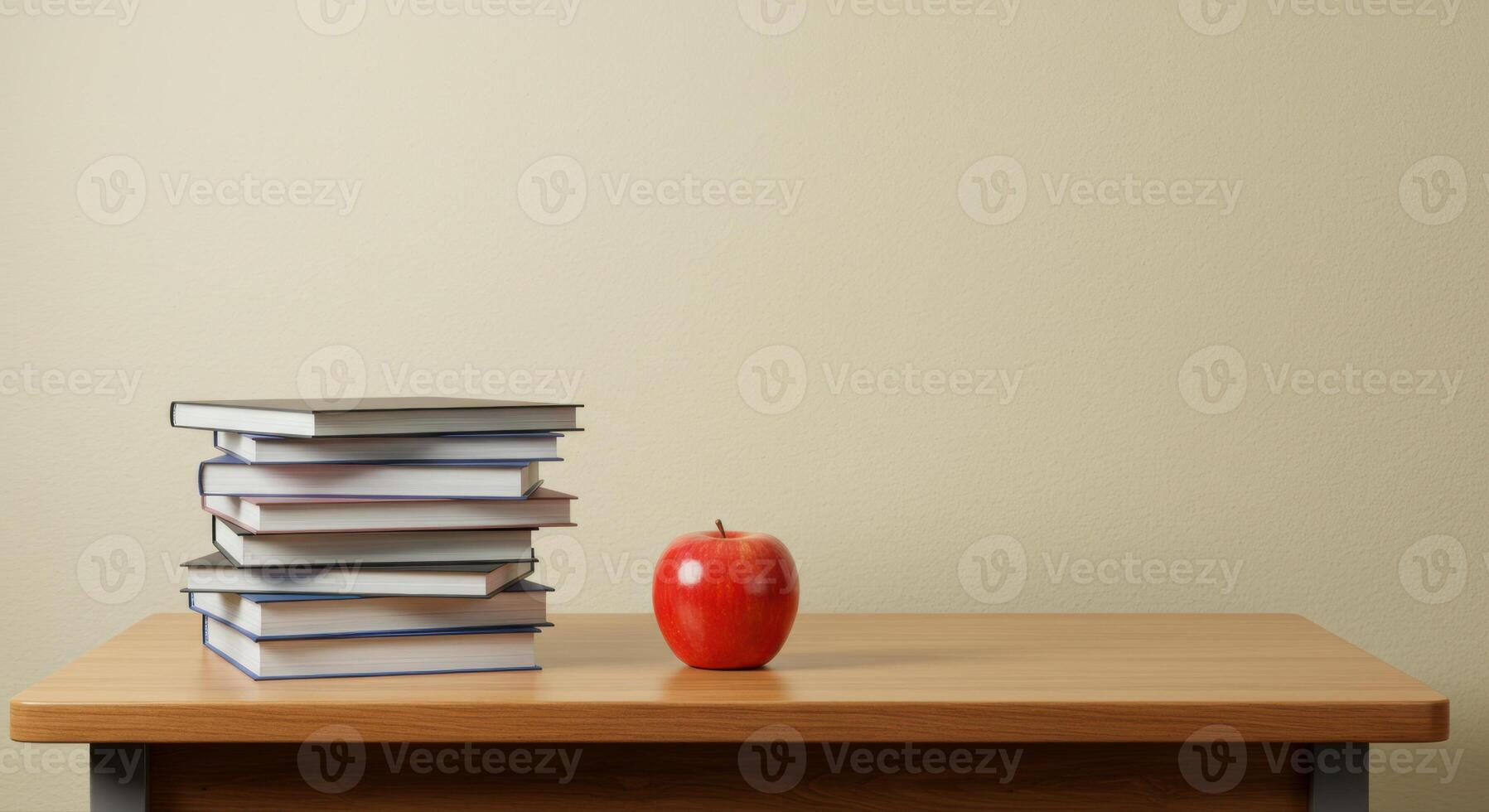 A red apple next to a pile of books on a wooden desk, perfect for education. photo
