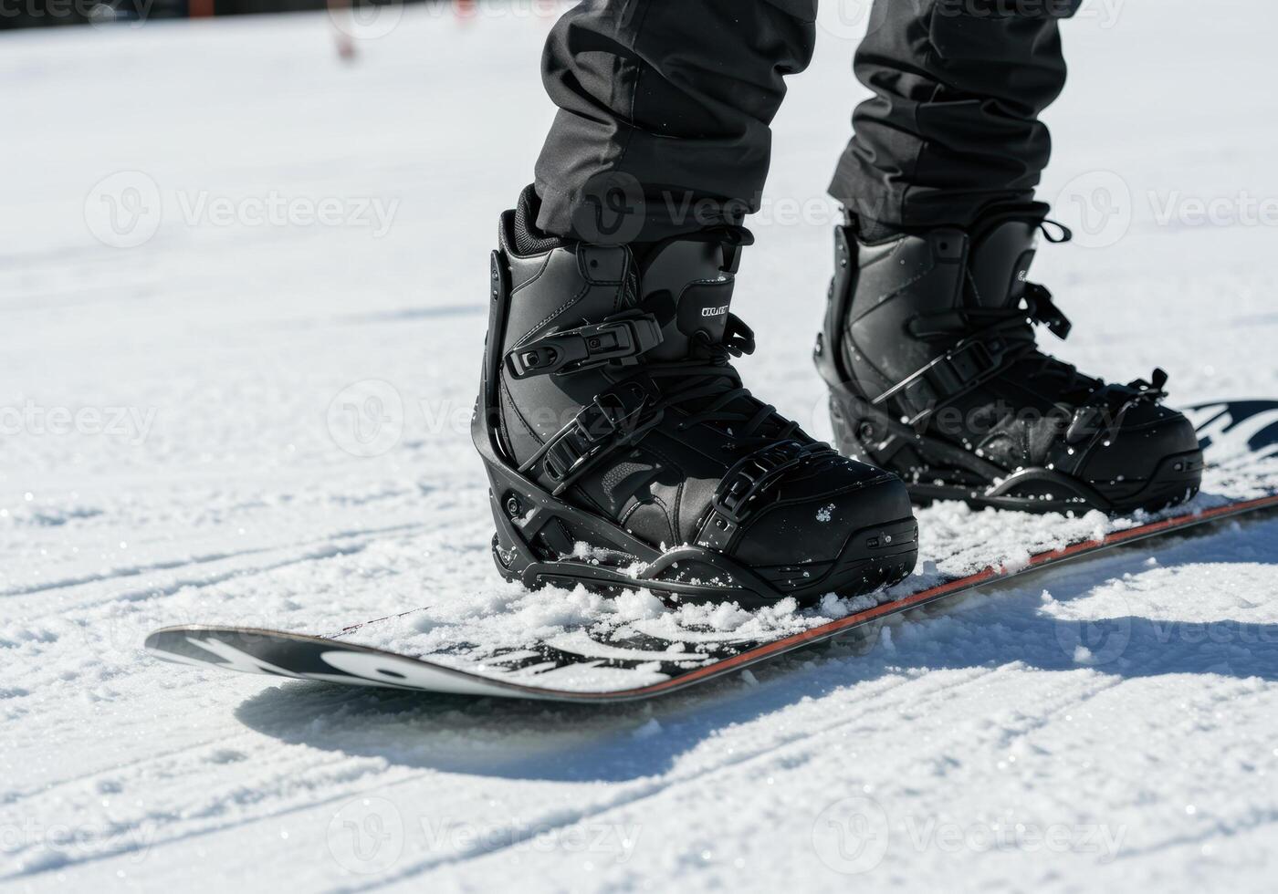 A close up view of snowboard boots attached to a snowboard on a fresh snowy surface. photo