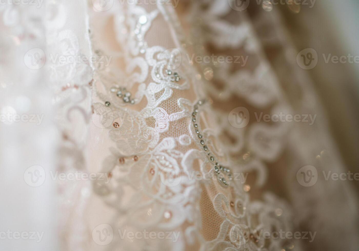 Close-up of a beautiful wedding dress, showcasing intricate lace details and beadwork. photo