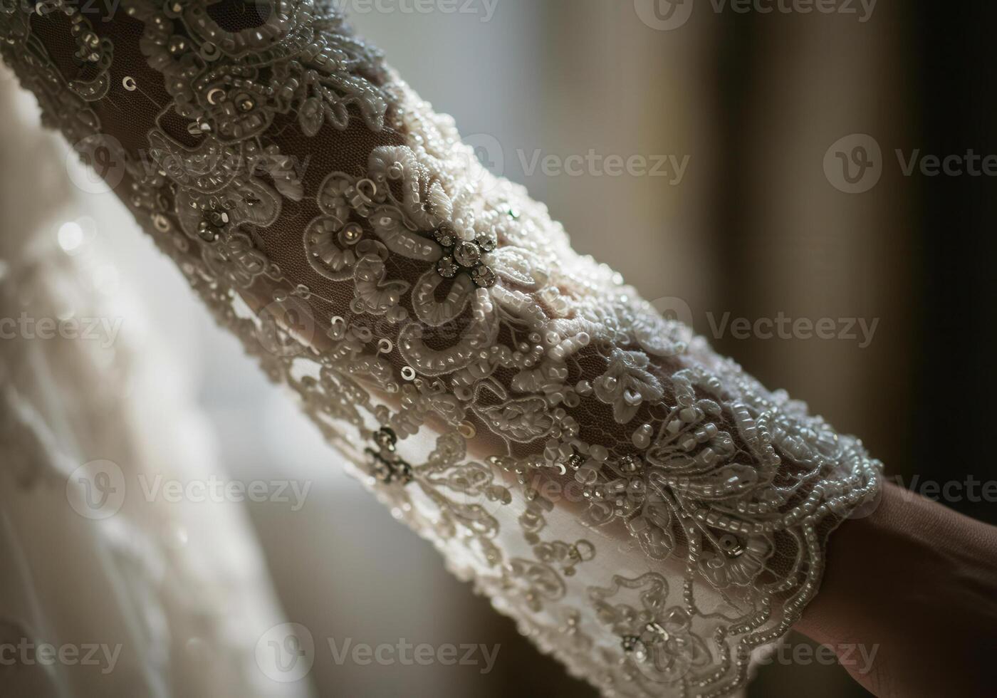 Intricate details of a bride's embellished sleeve, showcasing delicate lace and shimmering beads. photo
