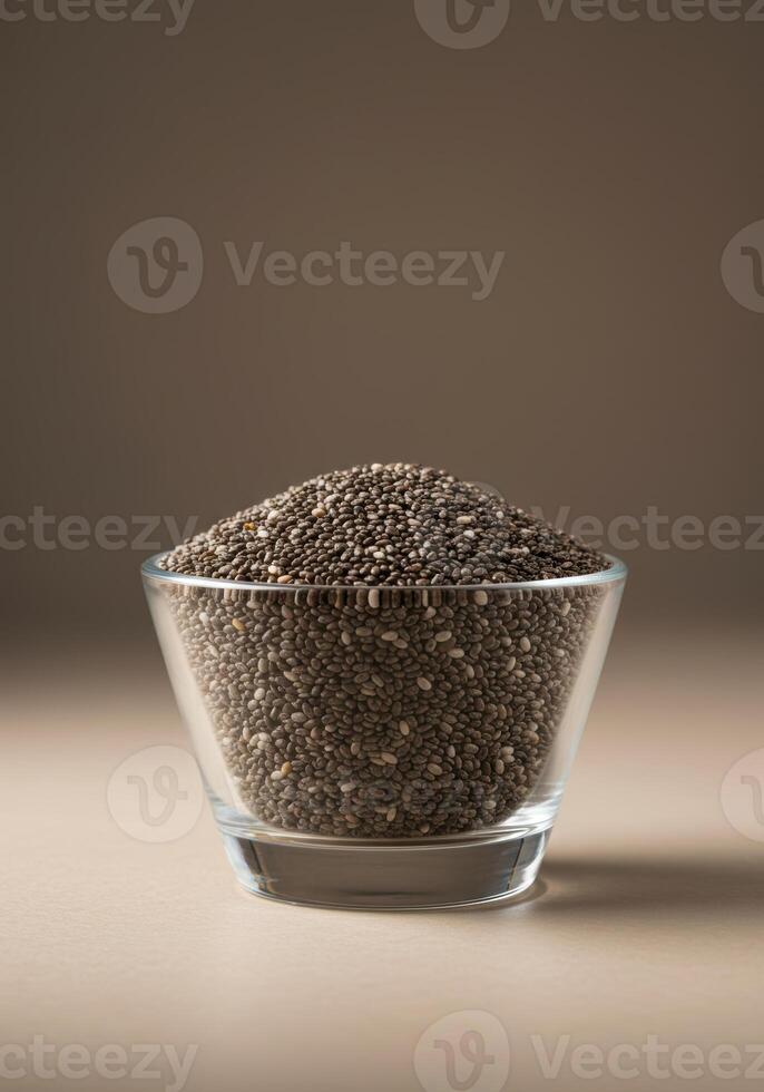 A clear glass bowl filled with a generous serving of chia seeds against a neutral background. photo