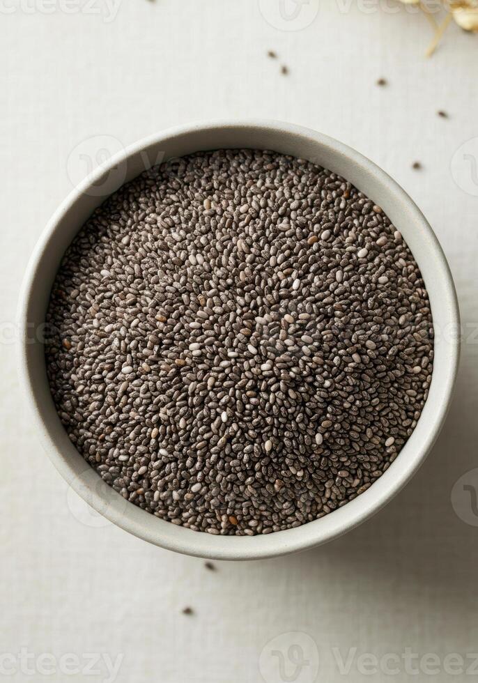 A full bowl of chia seeds viewed from above on a soft, white surface. photo