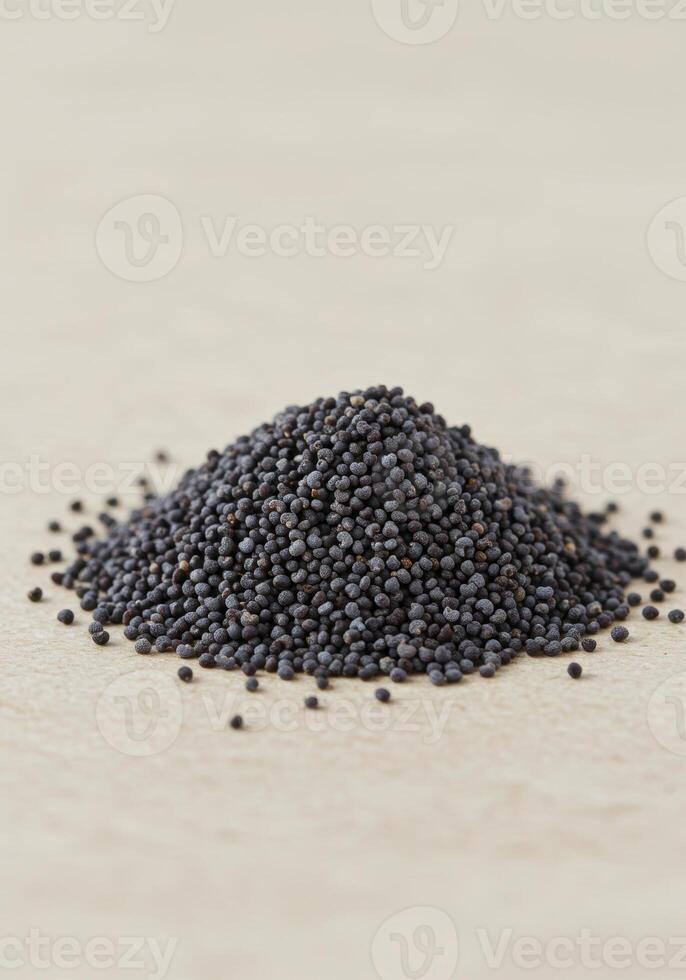 A mound of tiny dark poppy seeds sits on a neutral surface, capturing texture. photo