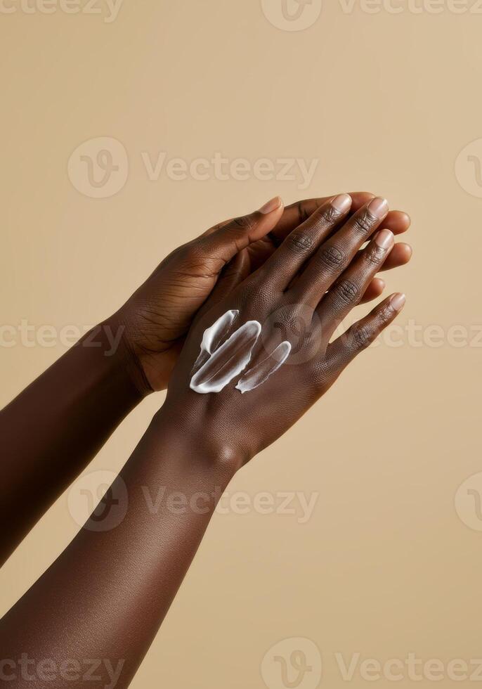 A close-up shot of hands applying cream on a beige background, promoting beauty. photo