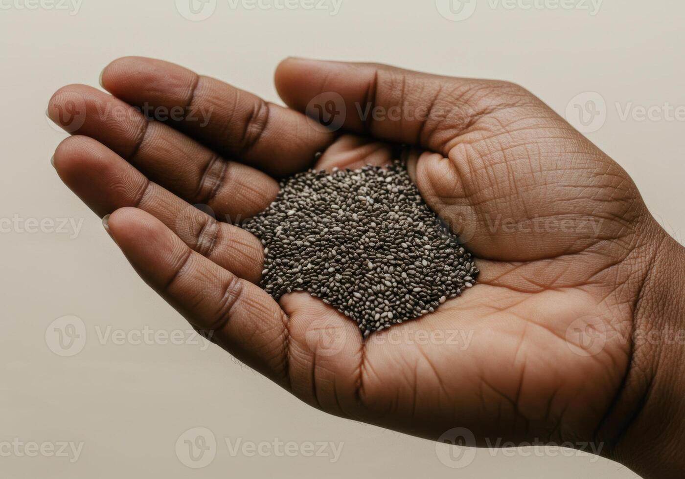 A close-up shot shows chia seeds held in a person's open hand. photo