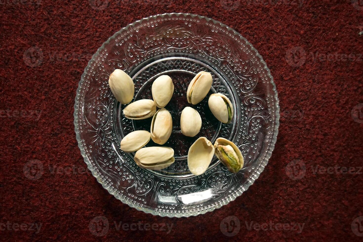 Flat lay view of Pistachio nuts or Pistacia vera, a cashew related seed that can be eaten fresh or roasted and is commonly used in a variety of desserts. photo