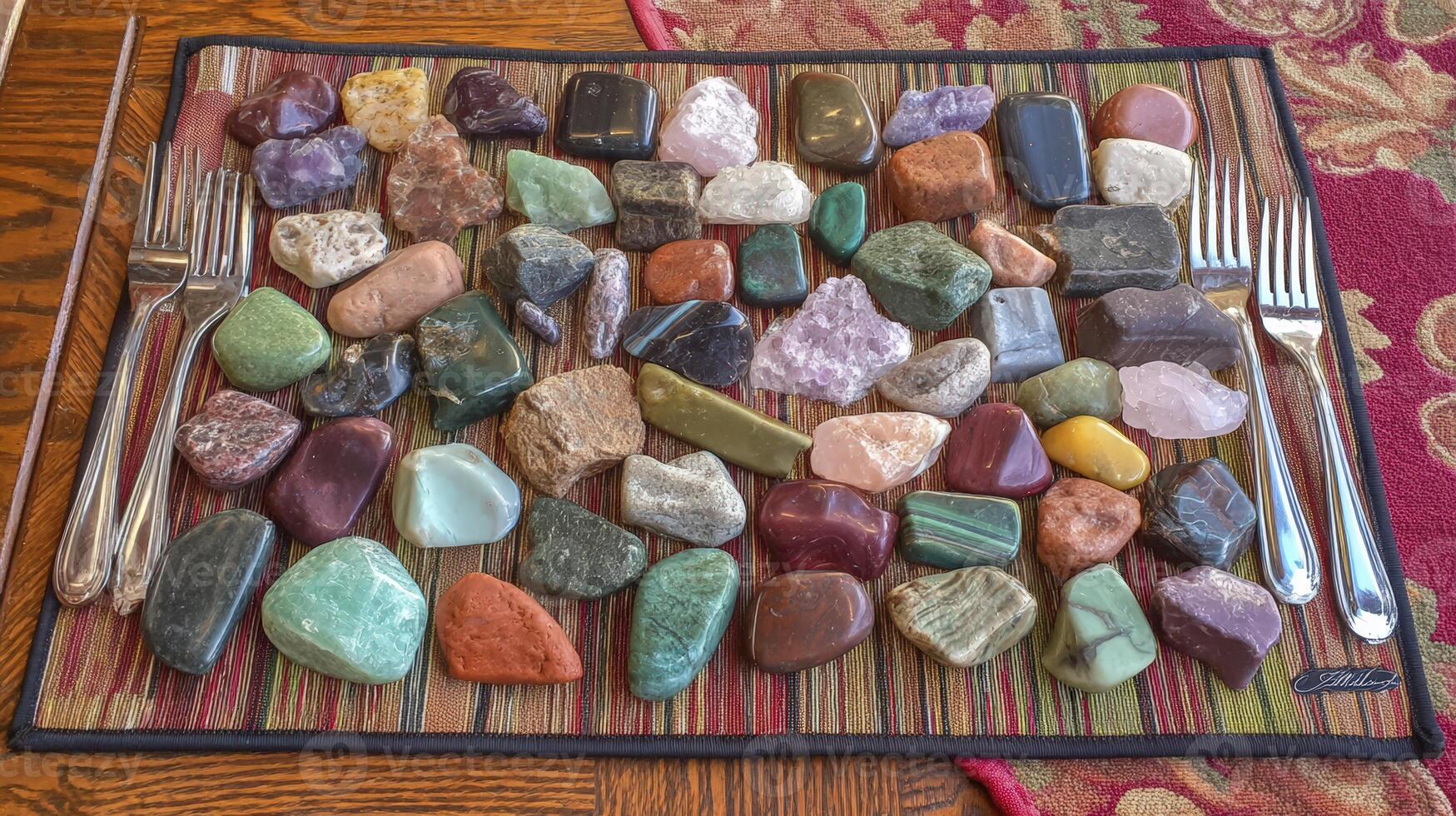 Colorful Tumbled Stone Collection Displayed on Woven Mat photo