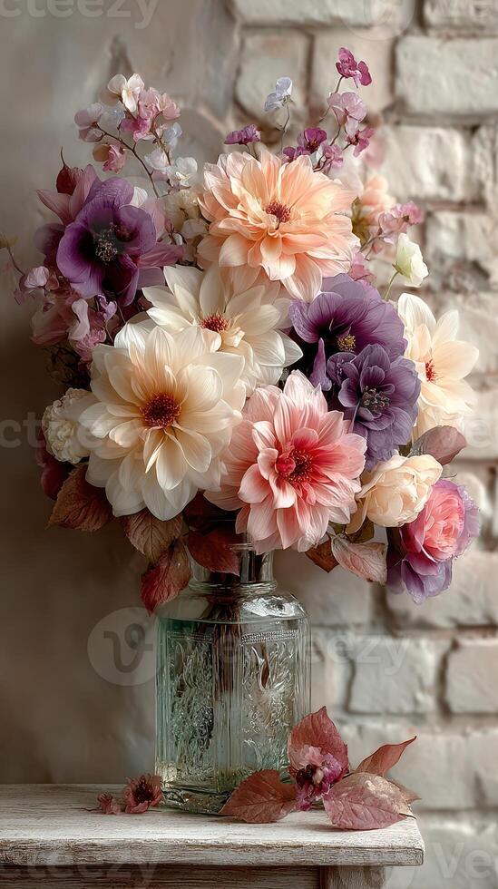 Colorful floral arrangement in a vintage glass vase set against a textured brick wall photo