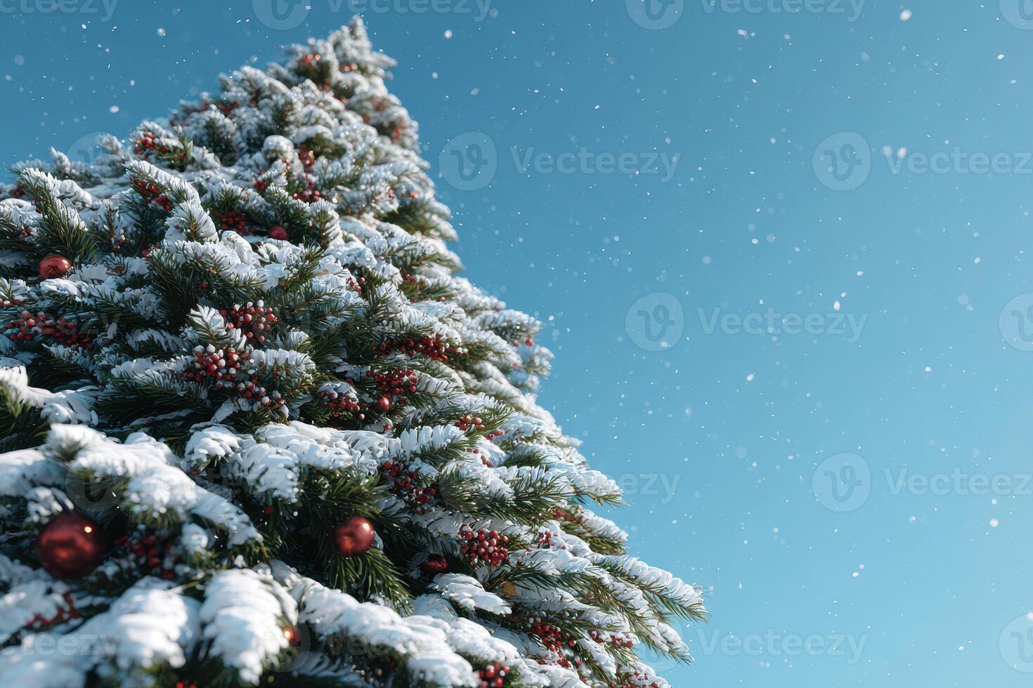 Snow-covered Christmas tree adorned with ornaments against a clear blue sky in winter photo