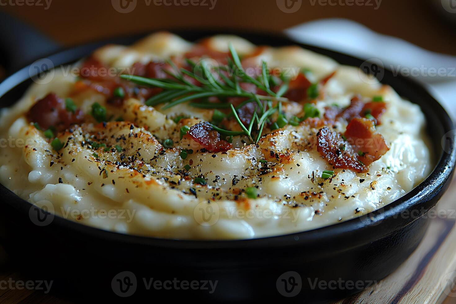 Creamy Mashed Potatoes Topped with Bacon and Herbs in a Black Skillet photo