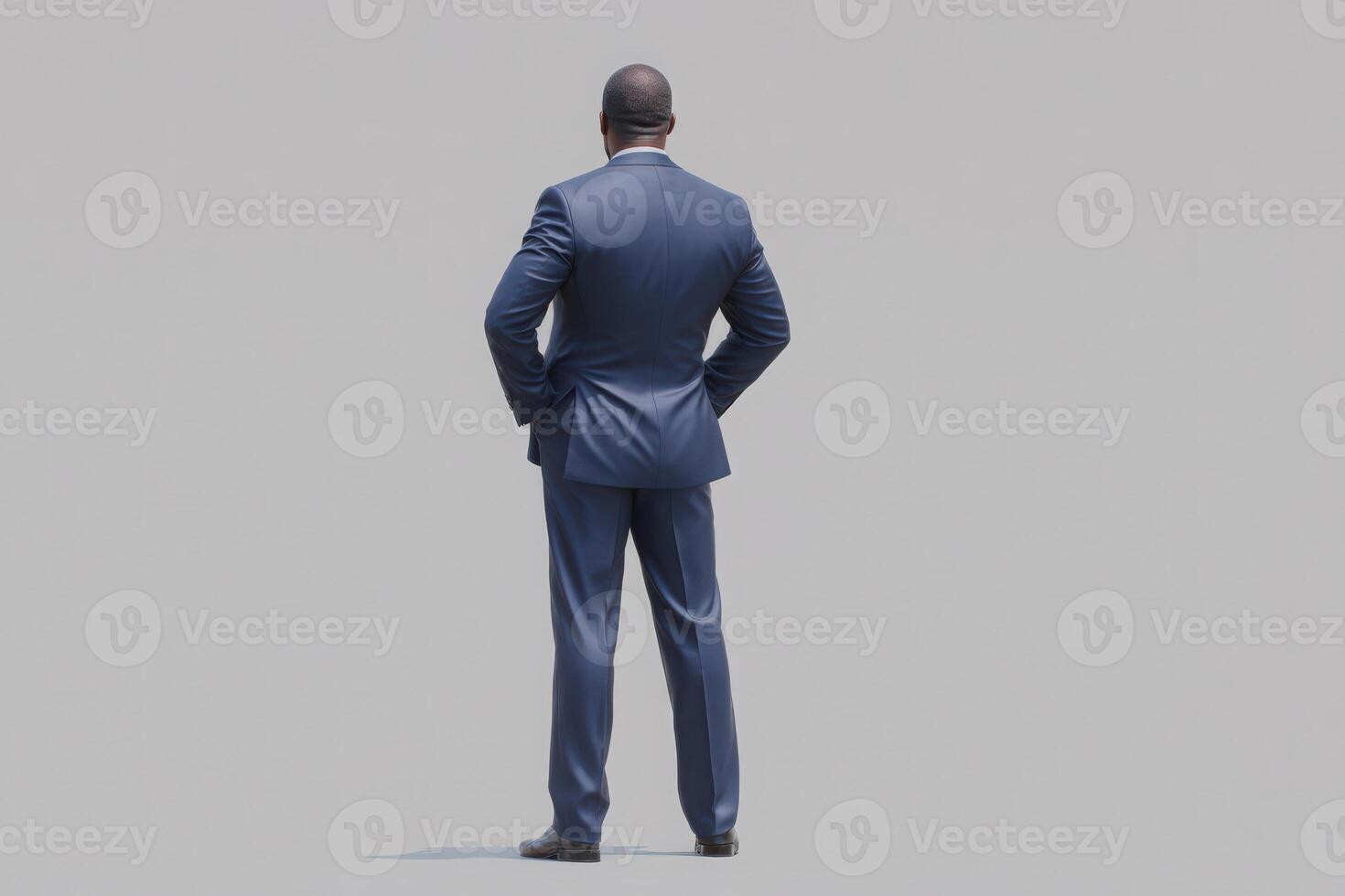 A businessman dressed in a tailored blue suit stands with his back facing the viewer, exhibiting a confident posture. The plain background emphasizes his presence and professionalism. photo