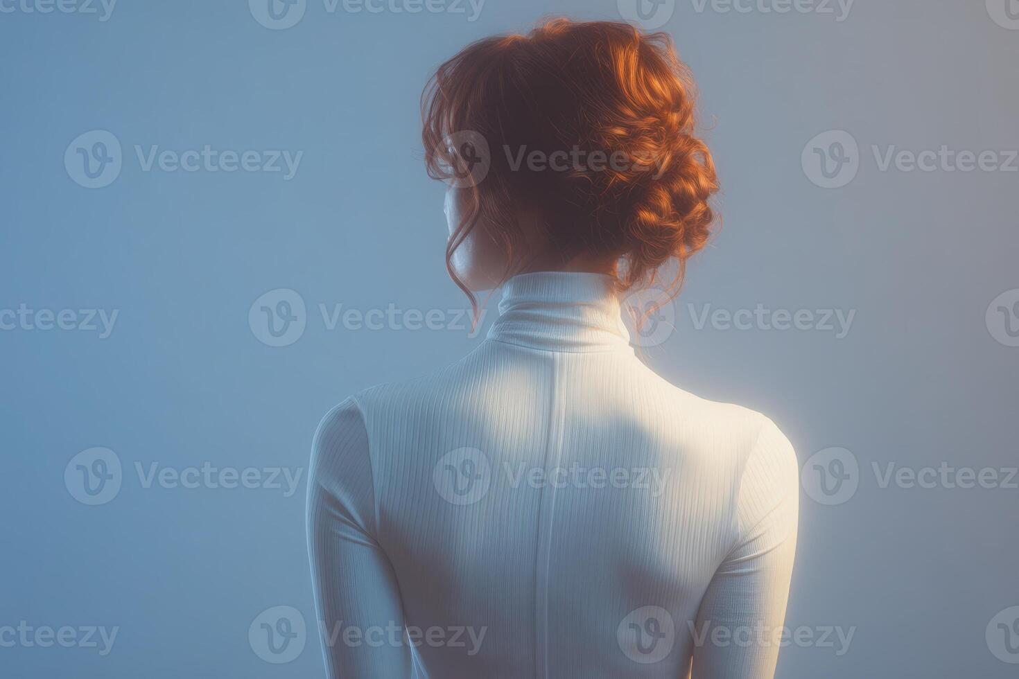 A woman stands with her back to the viewer, her hair styled in a bun. Soft blue lighting creates a calming atmosphere, emphasizing her graceful posture and minimalist outfit. photo