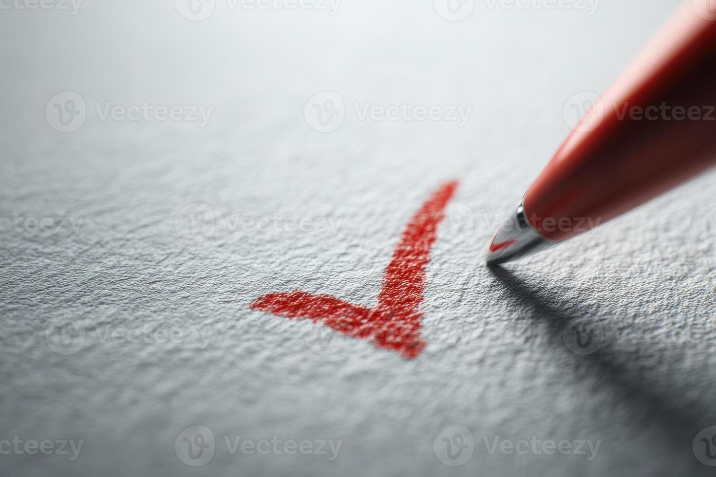 A close-up view of a red pen poised to complete a checkmark on a sheet of textured paper, representing finished tasks or confirmed items. The background is softly blurred. photo