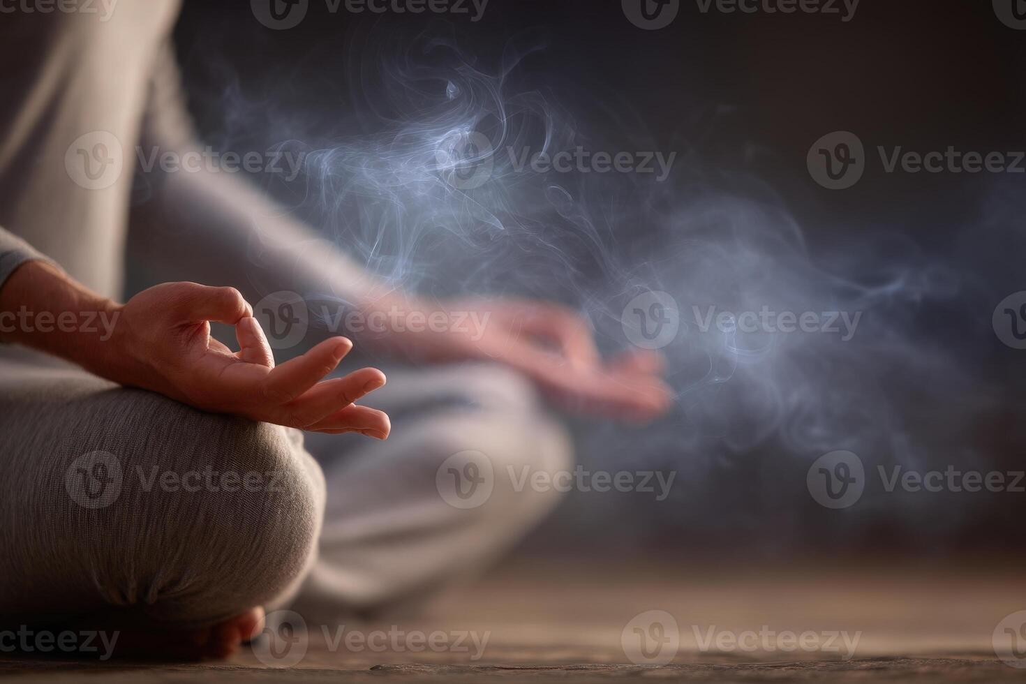 A person is meditating in a calm atmosphere, surrounded by a soft haze of smoke. The setting is dimly lit, creating a peaceful and introspective mood during twilight. photo