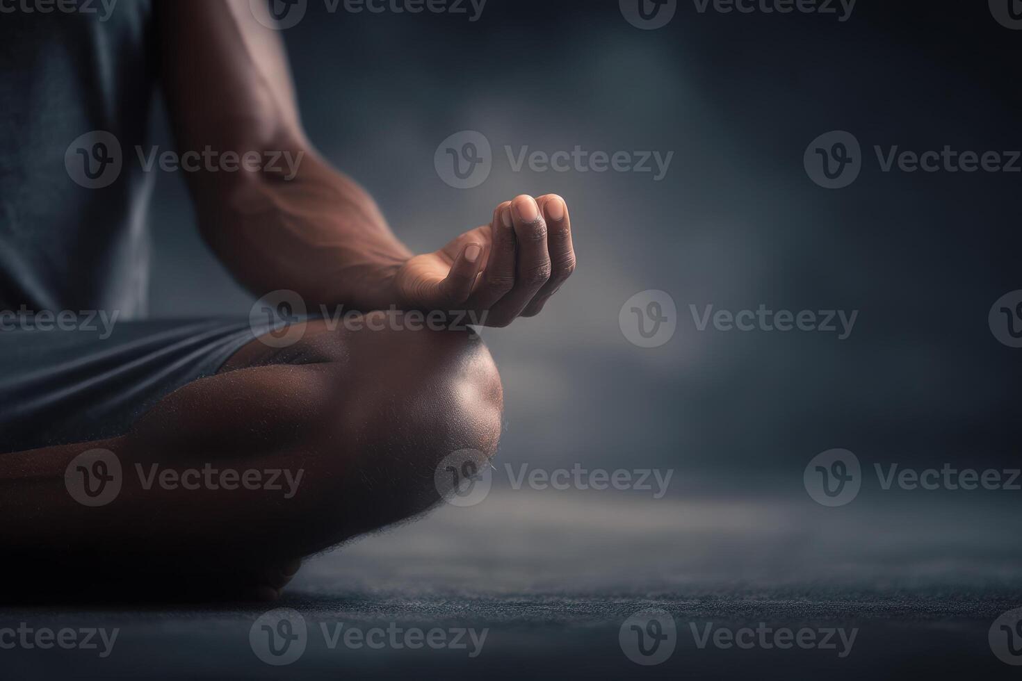 A person sits cross-legged in a calm atmosphere, practicing meditation. The focus is on the hands in a mudra, with soft lighting enhancing the tranquil mood. photo