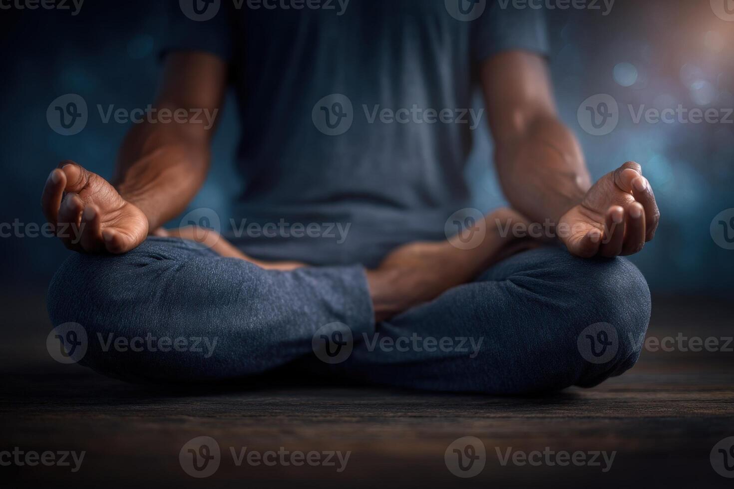 A person sits cross-legged on a wooden surface, practicing meditation. The hands rest on knees in a mudra position, while a calm and tranquil atmosphere surrounds them. photo