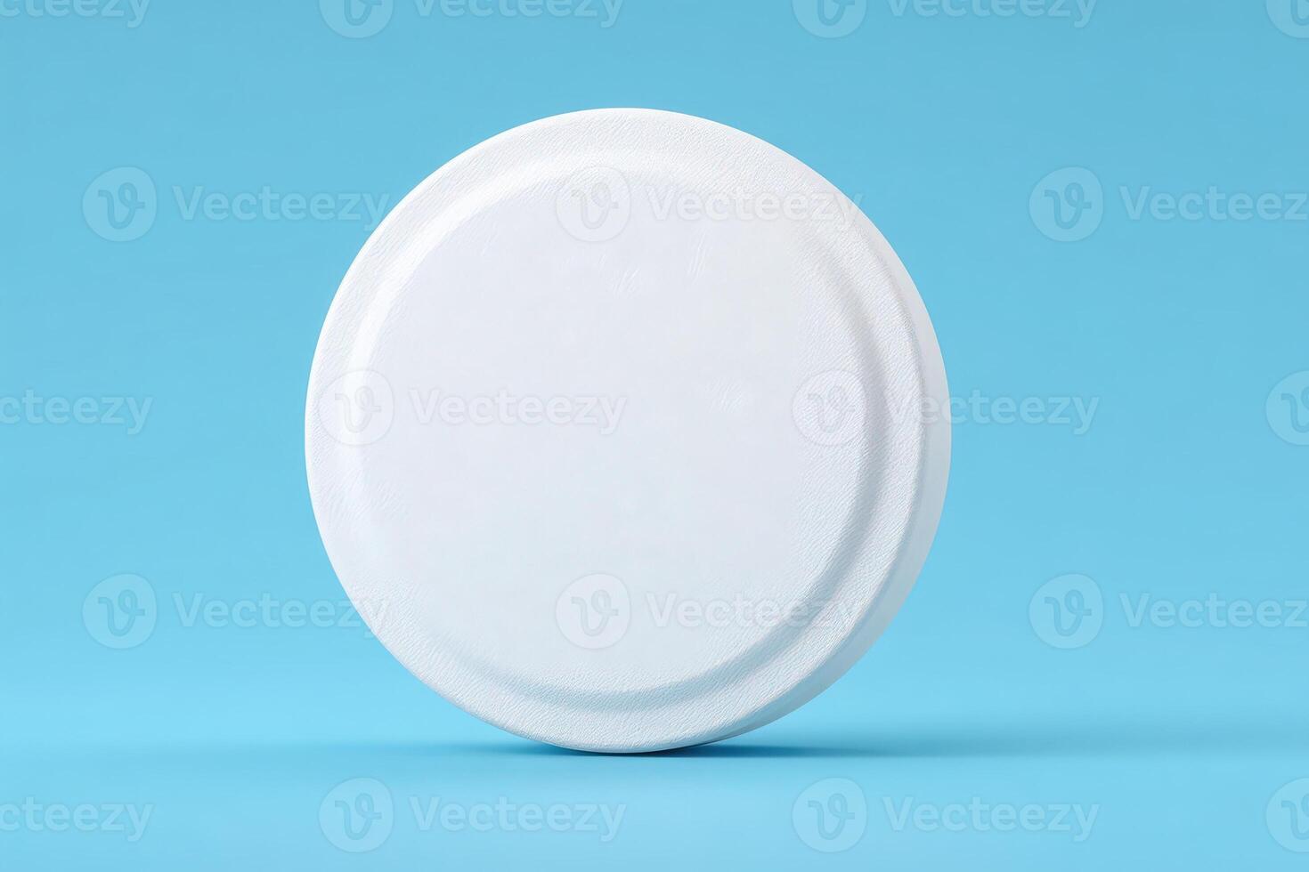 A plain white circular object is centered against a vibrant blue background, emphasizing its smooth texture and minimalist design. Ideal for showcasing simplicity in decoration or product display. photo