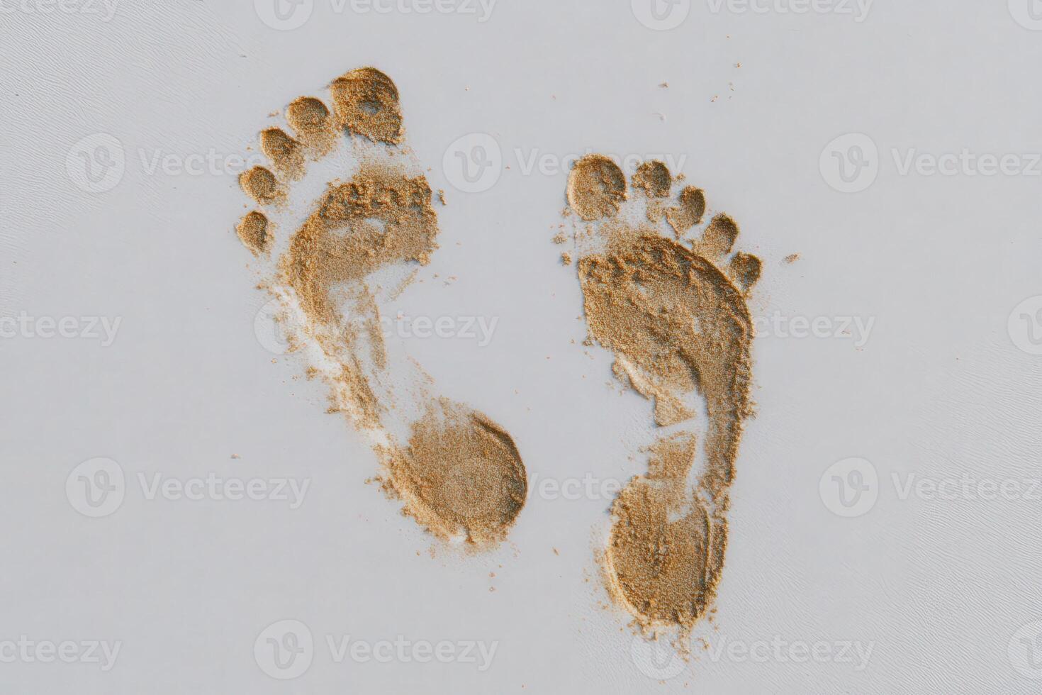 Fresh footprints are visible in fine sand, suggesting someone has recently walked along the shoreline. The light reflects off the sand, creating a peaceful beach atmosphere. photo