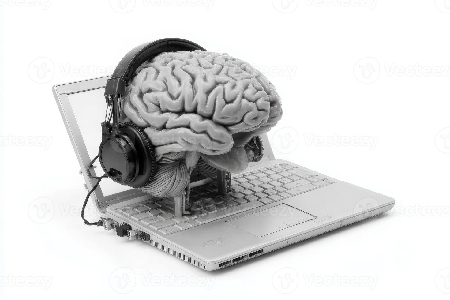 A realistic brain model rests on an open laptop, connected with headphones. This creative representation bridges the gap between human cognition and technology in a unique way. photo