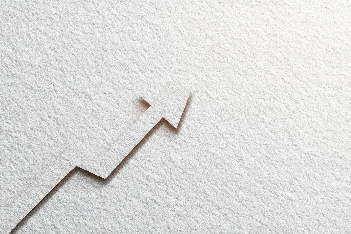 An upward arrow is intricately cut into textured paper, suggesting financial growth or progress. The simple yet striking design emphasizes the theme of upward momentum on a plain background. photo