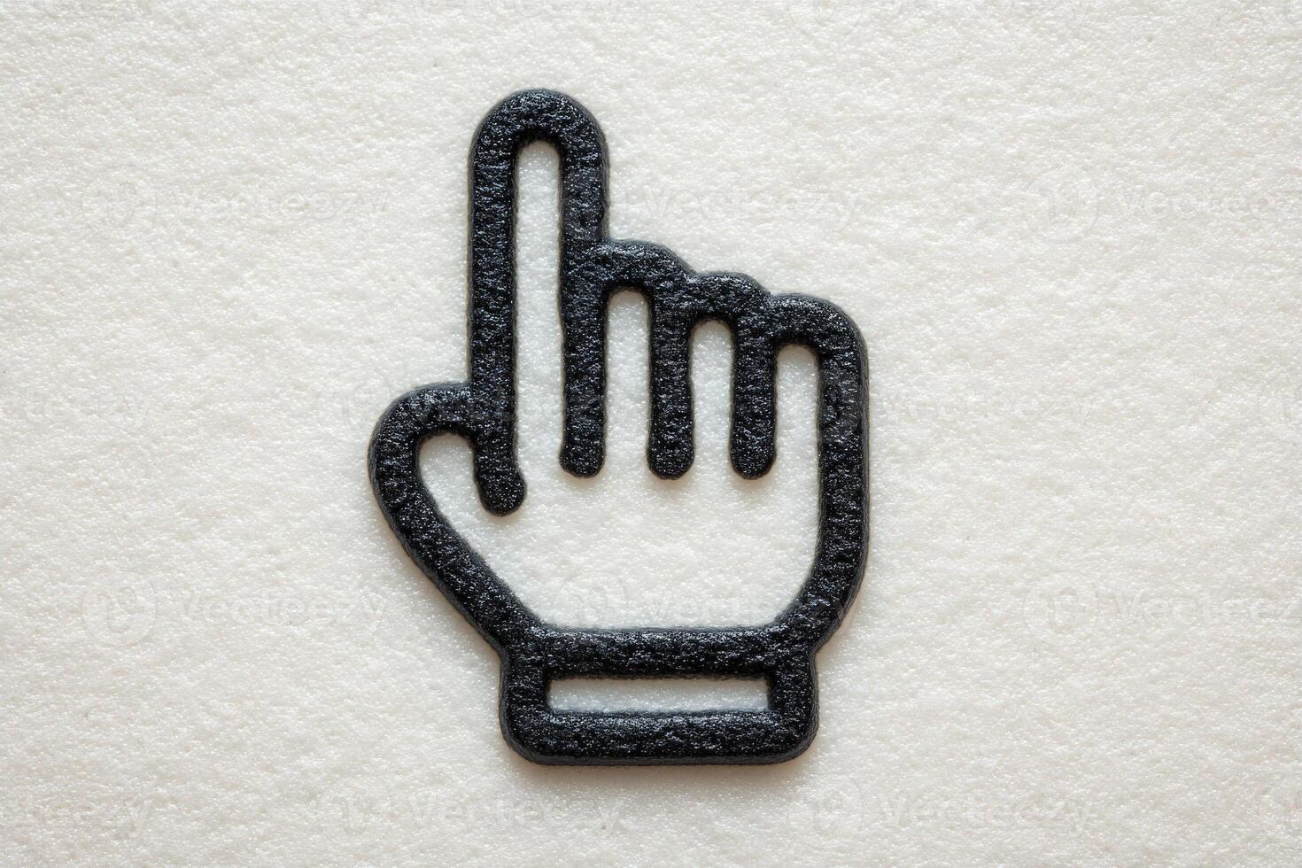 A textured surface features a black hand gesture symbol, specifically an index finger pointing upwards, indicating stop or attention. The design emphasizes simplicity and clarity. photo