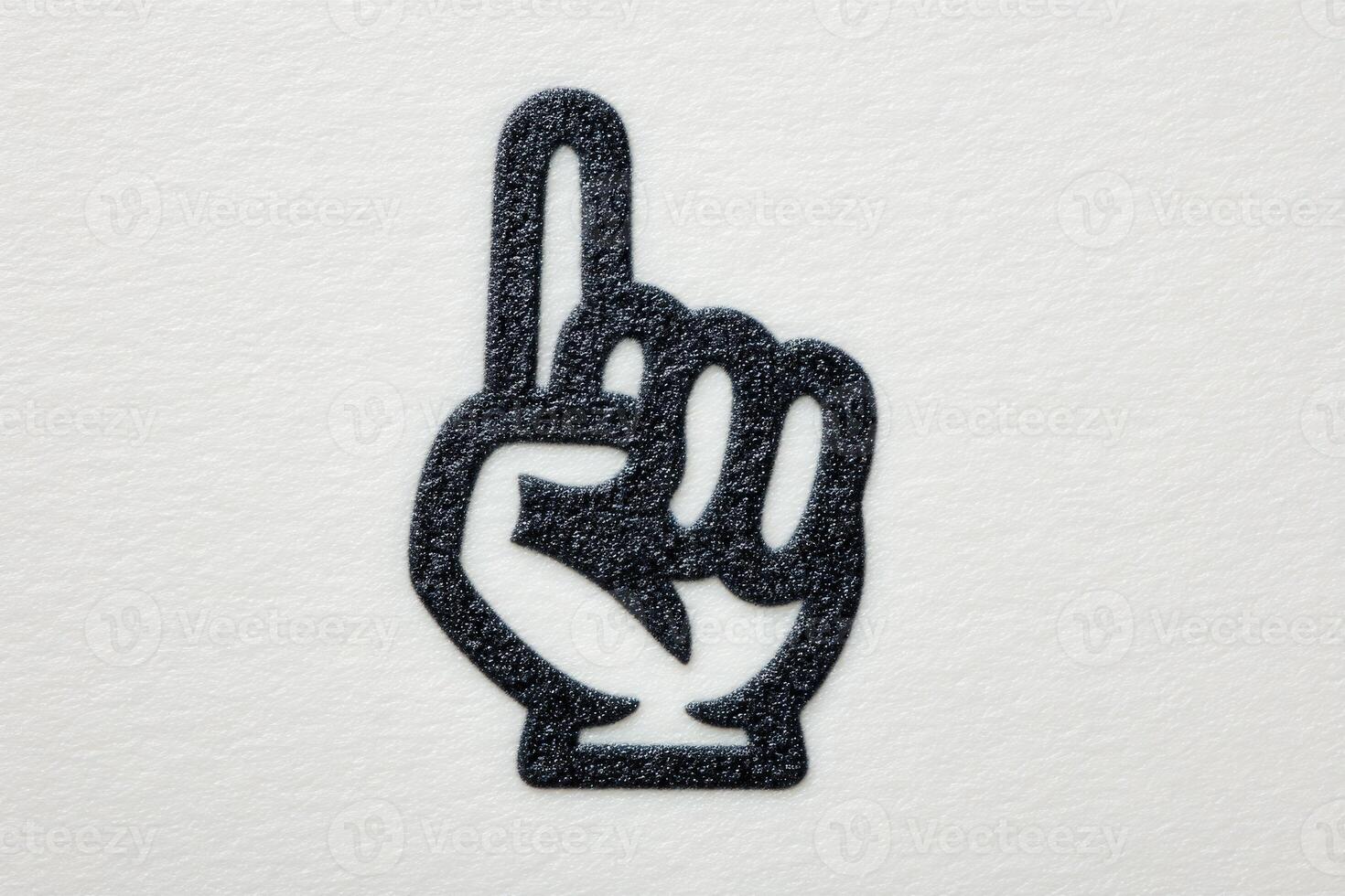 A black hand symbol with an extended index finger is displayed on a clean white surface. This gesture signifies number one and can represent encouragement or branding. photo