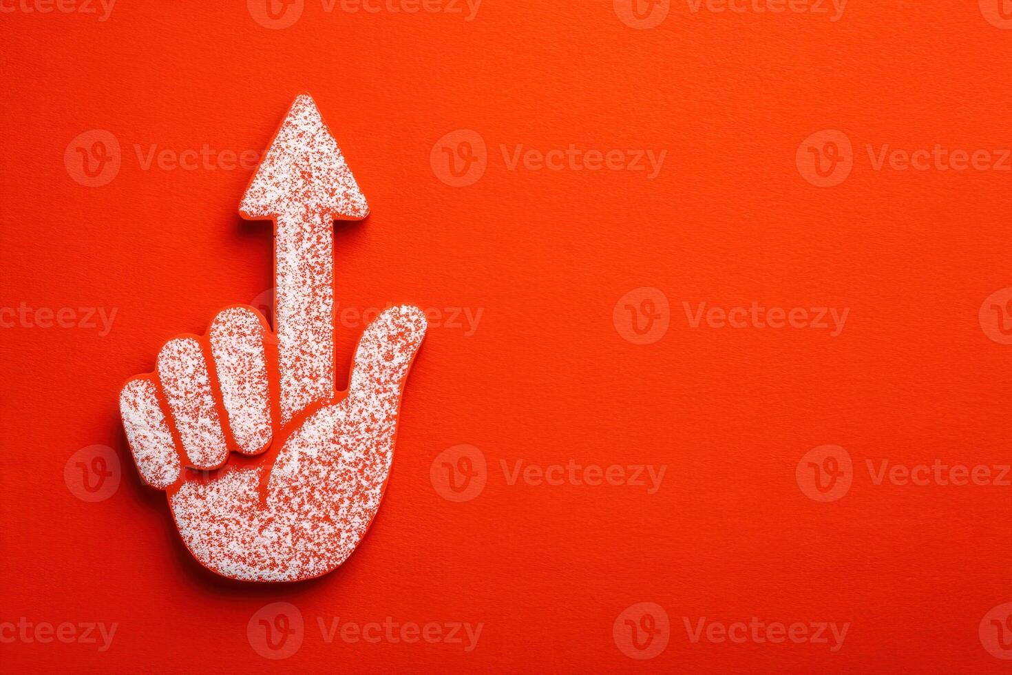 A hand gesture with a raised finger points upward against a vivid orange background. The textured hand is shown clearly, emphasizing the upward direction, suggesting importance or attention. photo