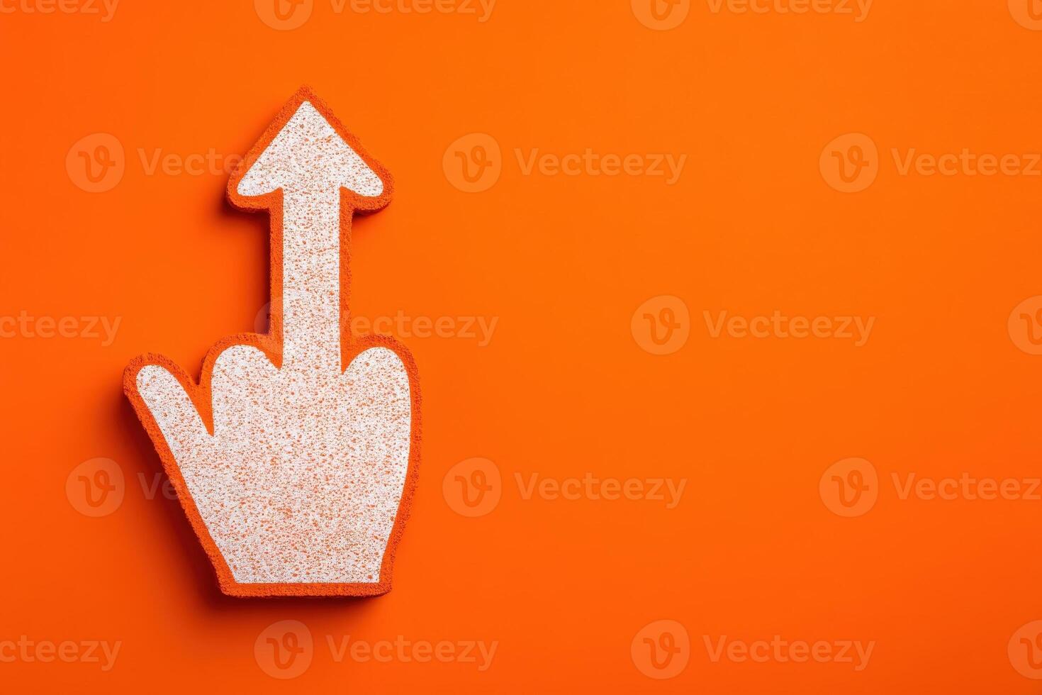 A hand shaped object with a raised finger is placed on a bright orange surface. The gesture is often used for emphasis or expression, making it visually striking and bold. photo