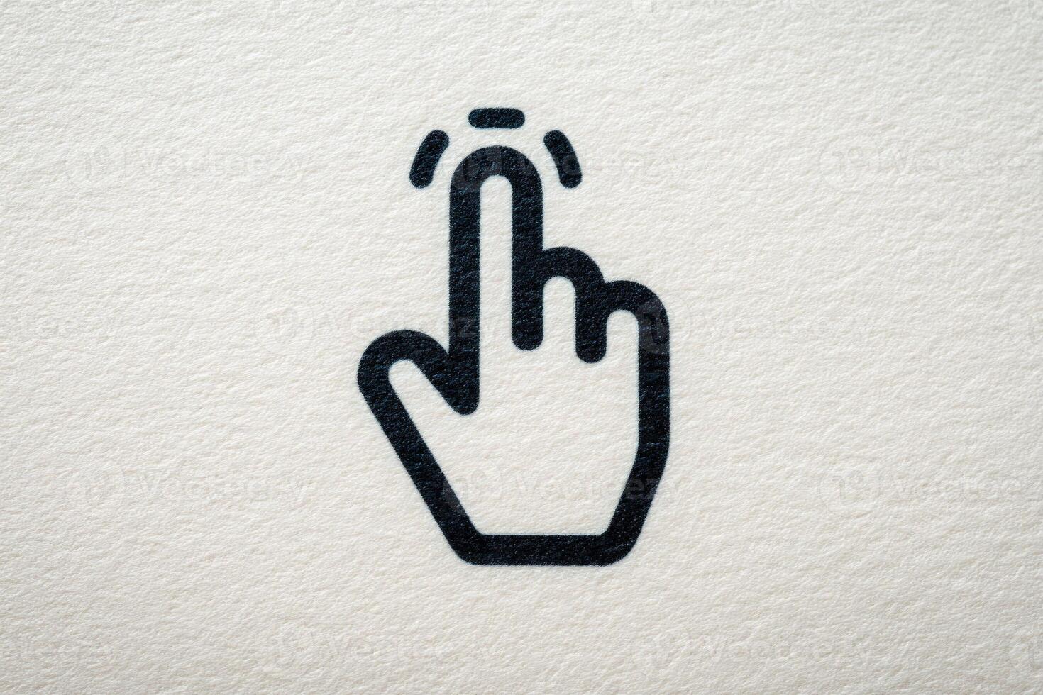 A simple black icon of a hand pointing upwards, suggesting a tapping or clicking action. The background features a light, textured surface, enhancing the symbols clarity and focus. photo