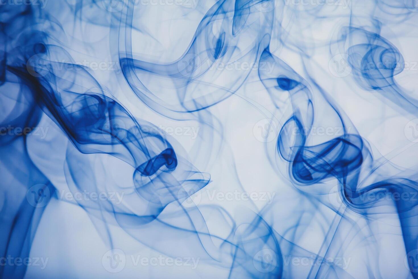 A mesmerizing display of blue smoke gracefully swirls across a light background, forming intricate, flowing patterns. The ethereal shapes blend seamlessly, creating an artistic composition. photo