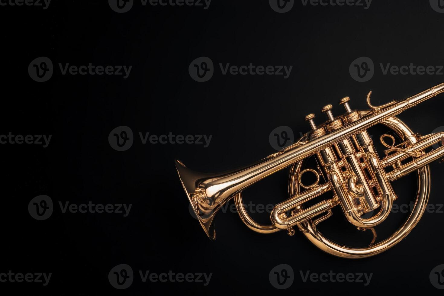 A brass trumpet rests against a black backdrop, highlighting its shiny surface and intricate details. The instrument reflects light, showcasing its craftsmanship and design, perfect for music lovers. photo