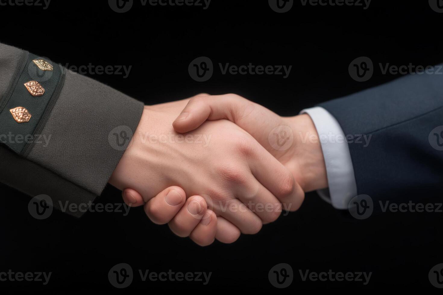 Two hands meet in a firm handshake, one dressed in a military uniform and the other in a business suit. This gesture signifies unity and cooperation in a formal setting. photo