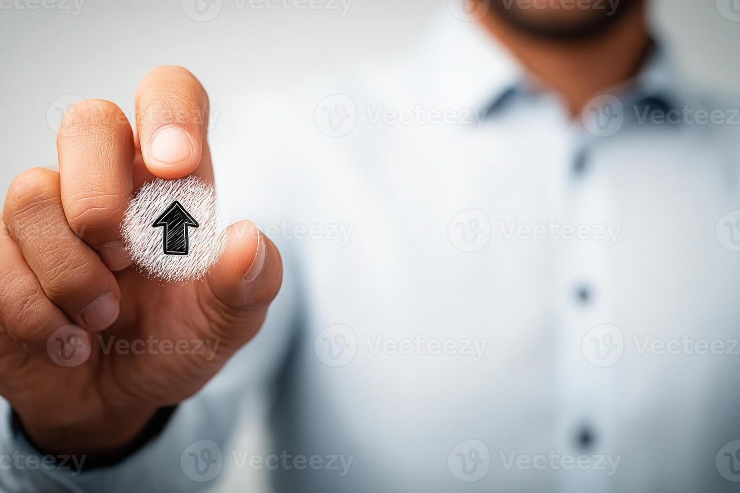 A person is holding a hand-drawn upward pointing arrow symbol, symbolizing growth and advancement. The setting appears to be a modern office, emphasizing professionalism and motivation. photo