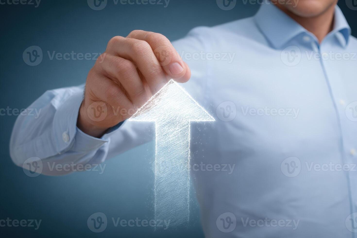 A business professional in a light blue shirt uses their hand to create a digital upward arrow. This action symbolizes growth and progress in a contemporary workspace setting. photo